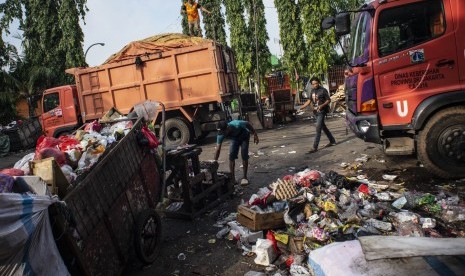 Warga beraktivitas di dekat truk pengangkut sampah di area proyek Fasilitas Pengolahan Sampah Terpadu atau Intermediate Treatment Facility (ITF) Sunter, Jakarta, Selasa (12/2/2019).