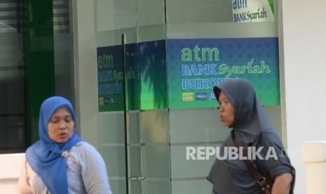  Warga beraktivitas di depan mesin Anjungan Tunai Mandiri (ATM) Bank Syariah Bukopin, Jakarta, Ahad (10/9).