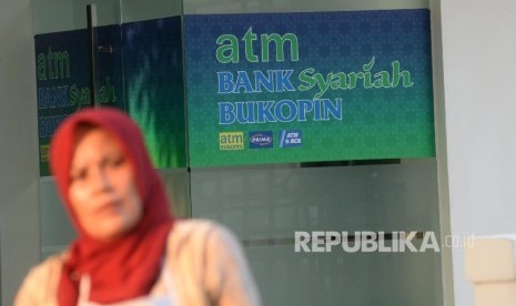  Warga beraktivitas di depan mesin Anjungan Tunai Mandiri (ATM) Bank Syariah Bukopin, Jakarta, Ahad (10/9). 