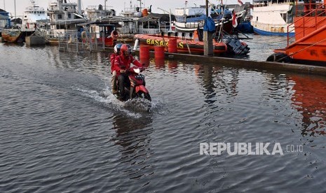 Warga beraktivitas di Jalan Yos Sudarso yang terendam rob (banjir pasang air laut) di Tanjung Emas, Semarang, ilustrasi