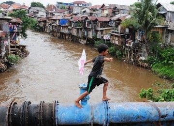 Warga beraktivitas di kawasan permukiman pinggiran Sungai Ciliwung, Manggarai, Jakarta Selatan, Selasa (31/1). (Aditya Pradana Putra)