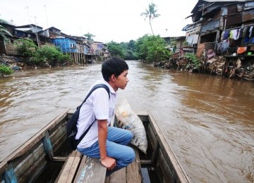 Warga beraktivitas di kawasan permukiman pinggiran Sungai Ciliwung, Manggarai, Jakarta Selatan, Selasa (31/1). (Aditya Pradana Putra)