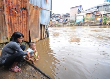 Warga beraktivitas di kawasan permukiman pinggiran Sungai Ciliwung, Manggarai, Jakarta Selatan, Selasa (31/1). (Aditya Pradana Putra)