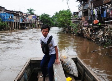 Warga beraktivitas di kawasan permukiman pinggiran Sungai Ciliwung, Manggarai, Jakarta Selatan, Selasa (31/1). (Aditya Pradana Putra)