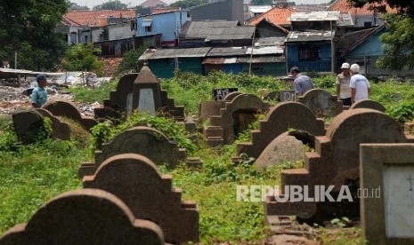 Warga beraktivitas di kawasan Tempat Pemakaman Umum (TPU) Menteng Pulo, Jakarta, Jumat (1/4).