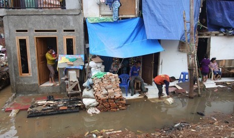 Warga beraktivitas di kediaman mereka yang tergenang air luapan Sungai CIliwung di Kampung Pulo, Jakarta, Jumat (13/11).