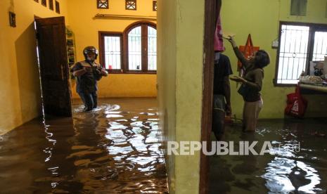 Warga beraktivitas di rumahnya yang terdampak banjir di Jalan Tawakal, Depok, Jawa Barat, Rabu (9/3/2022). Banjir di kawasan tersebut disebabkan meluapnya aliran kali akibat intensitas hujan yang tinggi dan drainase yang buruk. 