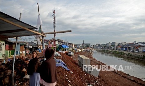 Warga beraktivitas di sekitar area proyek normalisasi Kali Cliwung di Kelurahan Bukit Duri, Jakarta, Senin (9/1)