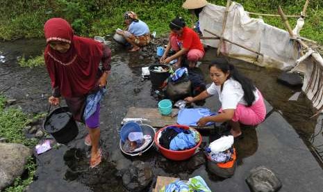 Warga beraktivitas mencuci baju dan piring di aliran Sungai Ciwulan Kampung Tamansari, di Tasikmalaya, Jawa Barat, Selasa (25/9).