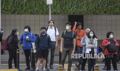 Warga beraktivitas menggunakan masker di kawasan Bunderan Hotel Indonesia, Jakarta, Senin (2/3/2020). 