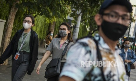 Warga beraktivitas menggunakan masker di kawasan Bunderan Hotel Indonesia, Jakarta, Senin (2/3/2020). 