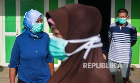 Warga beraktivitas menggunakan masker di Kota Tua Penagi, Natuna, Kepulauan Riau, Kamis (6/2/2020). 