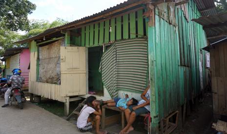 Warga berbincang-bincang di depan rumah mereka, di Kelurahan Remu Selatan, Kota Sorong, Papua Barat, Sabtu (20/2/2021). Badan Pusat Statistik (BPS) Kota Sorong menyatakan bahwa jumlah penduduk miskin Kota Sorong pada tahun 2020 sebesar 14,99% atau sebanyak 38.910 jiwa dari total jumlah penduduk Kota Sorong sebanyak 284,410 jiwa, menurun dari tahun 2019 yaitu sebesar 15,45% atau sebanyak 39.020 jiwa.