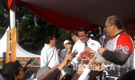 Warga berburu sembako dari Menteri Pertanian, Andi Amran Sulaiman dan Gubernur Jabar Ahmad Heryawan dalam rangka launching Pangan Murah Berkualitas melalui Toko Tani Indonesia di CFD Dago, Bandung, Ahad (15/5). (foto : Dede Lukman Hakim)