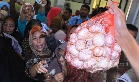 Warga berdesak desakan membeli bawang putih saat pembukaan Toko Tani Indonesia (TTI) di kawasan Pasar Minggu, Jakarta, Rabu (15/6). (Republika/ Agung Supriyanto)