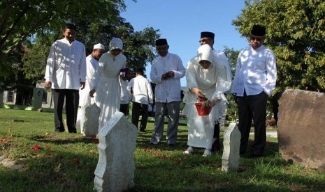  Warga berdoa bersama di kuburan massal korban tsunami Ulee Lheu, Banda Aceh, Rabu (26/12). (Antara/Irwansyah Putra)