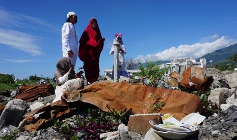 Warga berdoa di tempat hilangnya anggota keluarga mereka di lokasi bekas terdampak likuefaksi di Kelurahan Balaroa, Palu, Sulawesi Tengah, Rabu (5/6/2019). 