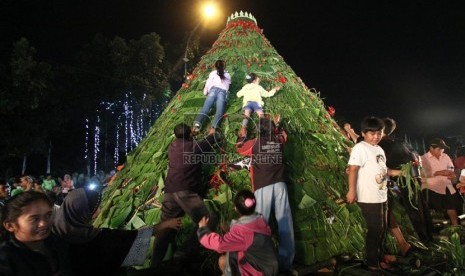  Warga berebut makanan tumpeng saat Perayaan Ulang Tahun ke 486 DKI Jakarta di Jalan Merdeka Selatan, Jakarta Pusat, Sabtu (22/6) malam.    (Republika/Yasin Habibi)