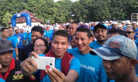 Warga berebut selfie dengan cawagub DKI Jakarta Sandiaga Uno dalam acara Jakarta BERLARI di Lapangan Banteng, Jakarta, Ahad (2/10)