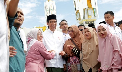 Warga berfoto dengan Presiden Joko Widodo setelah penyerahan sertifikat tanah wakaf kepada pengurus masjid, mushola dan pasantren seusai melaksanakan ibadah Jumat di Banda Aceh, Aceh, Jumat (14/12/2018).