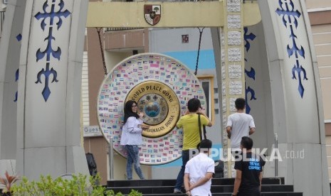  Warga berfoto di depan Gong Perdamaian Dunia (World Peace Gong di Kota Ambon, Maluku.