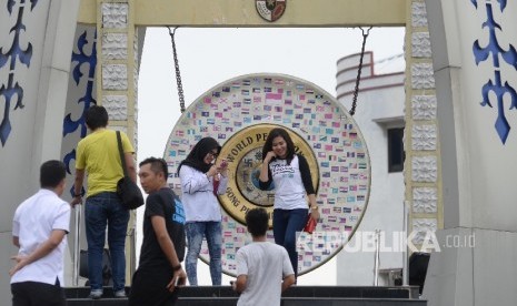 Warga berfoto di depan Gong Perdamaian Dunia (World Peace Gong0 di Kota Ambon, Maluku, Rabu (8/2). 