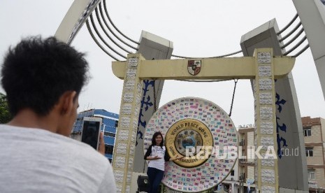 Warga berfoto di depan Gong Perdamaian Dunia (World Peace Gong0 di Kota Ambon, Maluku,