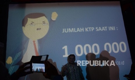 Warga berfoto di depan layar bertuliskan jumlah dukungan KTP sebanyak 1 juta di Sekretariat Teman Ahok, Jakarta, Ahad (19/6).