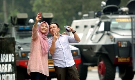 Warga berfoto di depan panser yang diparkirkan di dekat gedung Mahkamah Konstitusi (MK) Jalan Merdeka Barat, Jakarta Pusat, Kamis (21/8). Hari ini MK akan menggelar sidang putusan perselisihan hasil pemilihan umum (PHPU) presiden dan wakil presiden.