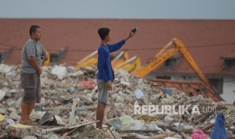 Warga berfoto selfie di bekas bongkaran pasar ikan kawasan Penjaringan, Jakarta Utara, Jumat (15/4). (Republika/Raisan Al Farisi) 