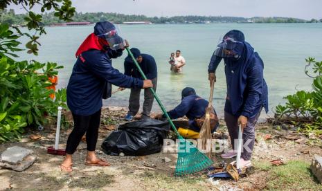 Warga bergotong royong membersihkan lingkungan area wisata. 