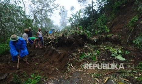 Warga bergotong royong membersihkan material longsor yang menutupi jalur alternatif Cepogo-Ampel lereng gunung Merbabu di Tarubatang, Selo, Boyolali, Jawa Tengah. 