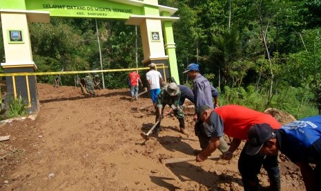 warga bersihkan jalan yang tertutup longsor (ilustrasi).