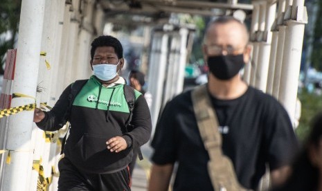 Warga berjalan dengan menggunakan masker di jalur pedestrian Jalan Jenderal Sudirman, (ilustrasi). Menteri BUMN Erick Thohir baru saja menerbitkan surat edaran terkait Antisipasi Skenario The New Normal BUMN tertanggal 15 Mei 2020. Erick mengizinkan karyawan usia 45 tahun ke bawah untuk kembali bekerja.