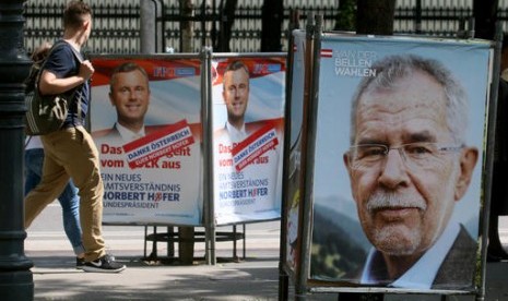 Warga berjalan di antara poster kampanye kandidat presiden Austria dan mantan ketua Partai Hijau Alexander Van der Bellen (kanan), dan kandidat presiden dari Partai Kebebasan Norbert Hofer (kiri), Senin, 23 Mei 2016.