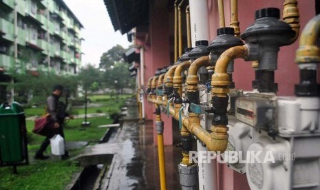 Warga berjalan di belakang meteran jaringan gas Perusahaan Gas Negara (PGN) di Rumah Susun Sewa (Rusunawa) Menteng, Bogor, Jawa Barat, Selasa (6/3). PT PGN menyalurkan gas alam ke 320 jaringan pipa di empat 