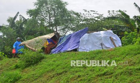 Warga berjalan di dekat tenda darurat di atas tanggul untuk mengungsi dari banjir, di Dusun Goleng, Pasuruan Lor, Kudus, Jawa Tengah, Rabu (3/2/2021). Beberapa warga memilih mengungsi di atas tanggul yang dekat dengan rumah mereka meskipun pemerintah setempat sudah menyediakan tempat pengungsian yang lebih aman.