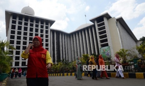  Warga berjalan di depan Masjid Istiqlal, Jakarta, Senin (2/1).