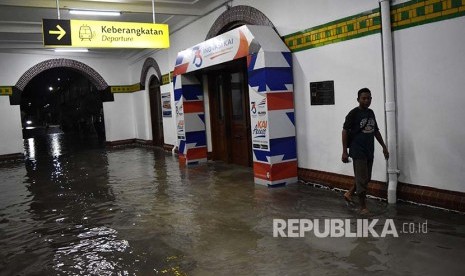 Warga berjalan di genangan air yang membanjiri ruang tunggu keberangkatan Stasiun Besar Kereta Api (KA) Tawang di Semarang, Jawa Tengah, Senin (3/12)