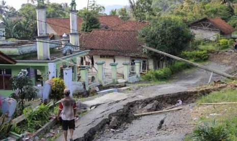 Warga berjalan di jalan desa yang rusak akibat pergerakan tanah di Kampung Cigintung, Desa Cimuncang, Kecamatan Malausna, Majalengka, Jawa Barat, Jumat (3/5)