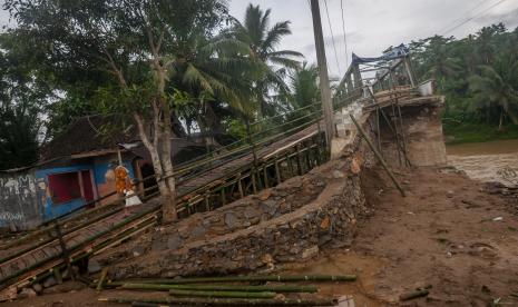 Warga berjalan di jembatan sementara di Sukajaya, Lebak, Banten, Selasa (11/10/2022). Bagian akses jembatan utama penghubung antarkecamatan tersebut rusak akibat diterjang banjir bandang pada Minggu (9/10/2022) sore. 