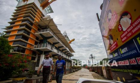 Warga berjalan di kawasan wisata Menara Pandang, Banjarmasin, Kalimantan Selatan, Selasa (3/8/2021). Pemerintah Kota Banjarmasin memutuskan untuk melanjutkan penerapan Pemberlakuan Pembatasan Kegiatan Masyarakat (PPKM) hingga 8 Agustus 2021 karena masih tingginya kasus aktif COVID-19 yaitu sebanyak 1.850 orang per 2 Agustus 2021 berdasarkan data Dinas Kesehatan Kota Banjarmasin. 