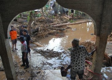 Warga berjalan di kawasan yang terkena banjir bandang, di Jorong Sawah Laweh, Nagari Simpang, Kecamatan Simpati, Kabupaten Pasaman, Sumbar, Kamis (23/2).