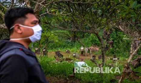 Warga berjalan di kompleks Tempat Pemakaman Umum (TPU). Ilustrasi