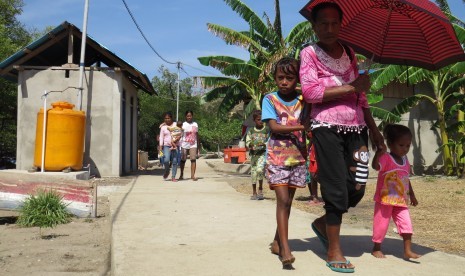 Warga berjalan di lingkungan pemukiman yang telah dialiri listrik di Desa Ustutun, Kecamatan Wetar Barat, Kabupaten Maluku Barat Daya, Provinsi Maluku, Kamis (21/9).