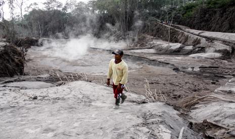 Warga berjalan di samping jalur lahar panas Gunung Semeru di kawasan Pronojiwo, Kabupaten Lumajang, Jawa Timur, Rabu (2/12).