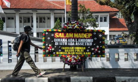 Warga berjalan di samping karangan bunga untuk terdakwa kasus penipuan investasi opsi biner Quotex Doni M. Taufik alias Doni Salmanan yang tengah menjalani sidang dakwaan di Pengadilan Negeri Bale Bandung, Baleendah, Kabupaten Bandung, Jawa Barat, Kamis (4/8/2022). Dalam sidang tersebut, Doni Salmanan didakwa meraih keuntungan sebanyak Rp4 miliar dari dugaan pencucian uang investasi aplikasi quotex. 