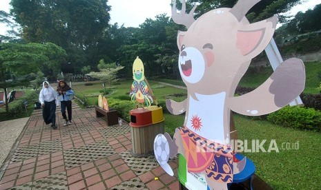 Warga berjalan di samping maskot Asian Games 2018 di Taman Sempur, Kota Bogor, Jawa Barat, Sabtu (19/5).