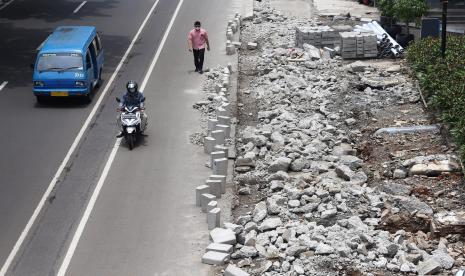 Warga berjalan di samping trotoar yang sedang direvitalisasi di Jalan Margonda Raya, Kota Depok, Jawa barat, Selasa (18/10/2022). 