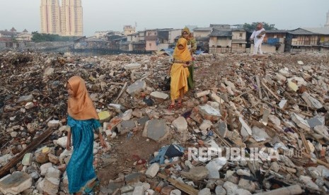  Warga berjalan diantara puing untuk mengikuti shalat Idul Fitri di bekas gusuran Pasar Ikan, Penjaringan, Jakarta Utara, Rabu (6/7).  (Republika/Raisan Al Farisi)